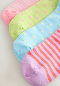 Quatre chaussettes en coton colorées posées côte à côte avec des motifs rayés et à pois dans des tons de rose, vert, bleu et violet sur une surface blanche.