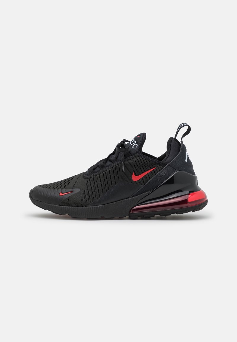 Baskets noires de sport avec une tige en maille, accents rouges et amorti visible au niveau du talon. Pointe renforcée et semelle texturée pour une meilleure adhérence.
