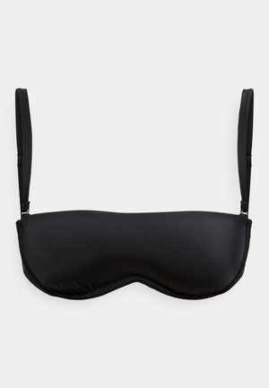 Svart bandeau-BH med tynne, justerbare stropper mot en ensfarget hvit bakgrunn.