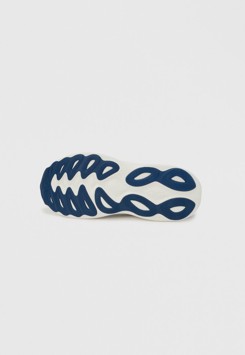 Suela de zapato con base blanca texturizada y patrón ondulado de goma azul, con recortes alargados para flexibilidad y agarre.