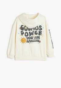 Haut à capuche crème avec un texte graphique à l'avant, une illustration de soleil jaune, et des motifs cosmiques colorés au dos et sur la manche.