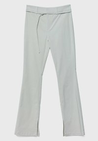 Pantalon gris clair à jambes droites avec passants de ceinture, une ceinture en tissu étroite, une fermeture éclair à l'avant et de petites fentes en bas de chaque jambe.