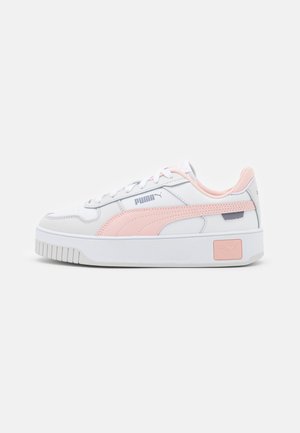 White sneakers with a thick sole, pink accents, and a textured design. Features leather and synthetic materials, with a lace-up closure.