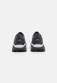 Adidași sport negri și gri cu un superior din plasă texturată, talpă albă cu amortizare, accente verzi și un tab pentru prindere la călcâi pentru a facilita încălțarea.