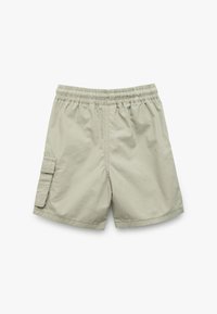 Pantalones cortos cargo de color beige claro con cintura elástica, que cuentan con un bolsillo lateral y una textura suave. Diseño simple sin patrones ni acentos.