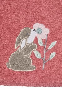 Rose-colored towel featuring a brown embroidered rabbit sniffing a pink flower with green accents and leaves, textured surface with loops.