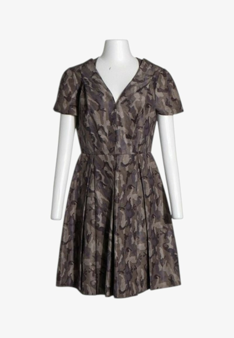 Robe à manches courtes avec motif camouflage brun et gris atténué, encolure en V, taille cintrée et jupe plissée sur torse de mannequin blanc.