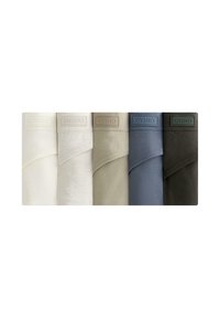 Cinque campioni di tessuto di cotone a maglia in beige, crema, verde chiaro, blu e verde scuro. Ognuno presenta un'etichetta in rilievo con la scritta "OYSHO."