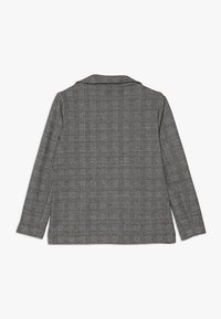 Blazer a maniche lunghe grigio a scacchi con colletto a revers e taglio dritto. Il tessuto presenta una finitura testurizzata con motivi a contrasto.