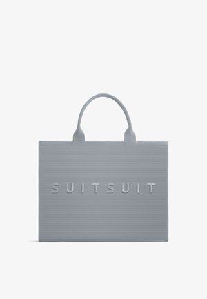 Grijze rechthoekige totebag met getextureerde horizontale lijnen en "SUITSUIT" gegraveerd op de voorkant, voorzien van twee afgeronde handgrepen.