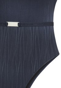 Costume da bagno in tessuto navy con motivo a onde verticali sottili e cintura elastica nera con fibbia piccola in argento.