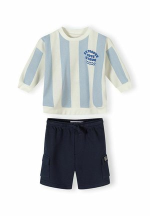 Koszula z długim rękawem w pionowe niebiesko-białe paski z napisem "St. Tropez Côte d'Azur", zestawiona z granatowymi szortami typu cargo.