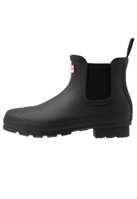 Black rubber Chelsea boot with elastic side panels, textured sole, and rear pull tab. Features a smooth finish and a sturdy design.