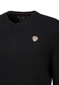 Schwarzer V-Ausschnitt-Pullover aus weichem Stoff, mit einem kleinen Schild-Logo auf der linken Brust und einem gestreiften Akzent am Innenkragen.