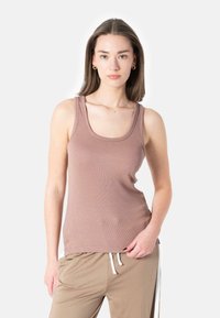 Light brown ribbed tank top with a rounded neckline and wide shoulder straps, paired with beige joggers featuring white side stripes.