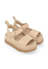 Sandales en daim beige avec orteils et talons ouverts, straps réglables et semelle en caoutchouc. Dotées d'une semelle intérieure rembourrée pour le confort.