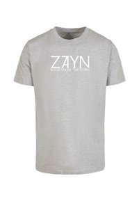 Pilkas medvilninis trumpomis rankovėmis T-shirt, kuriame ryškiu baltu tekstu yra išspausdinta: "ZAYN" ir "KAMBARYS PO LAIPTAIS", aiškiai matomas priekyje.