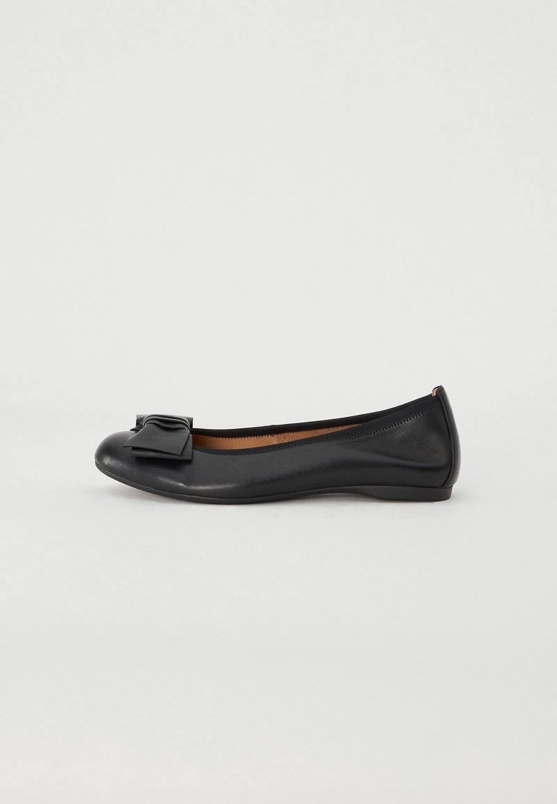 Ballerine plate en cuir noir avec bout arrondi et nœud décoratif sur le devant, présentée sur un fond blanc uni.