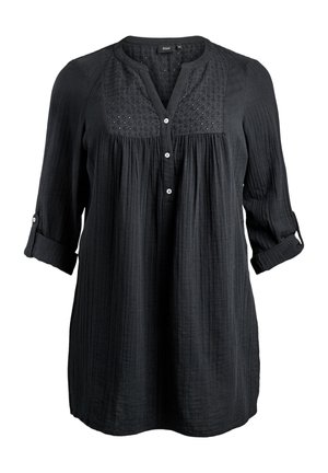Črna tunika z dolgimi rokavi iz teksturirane tkanine, z vezenim delom na prsih, zapognjenimi manšetami in tremi gumbi na sprednji strani.