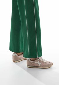 Sneakers in rosa chiaro e bianco, realizzati in suede e pelle. Progettati con un accento a forma di stella, lacci piatti e suola in gomma.