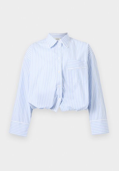 Μακρυμάνικο κοντό πουκάμισο με κάθετες ρίγες σε ανοιχτό μπλε και λευκό χρώμα, κλείσιμο με κουμπιά, μυτερό γιακά και μία τσέπη στο στήθος.