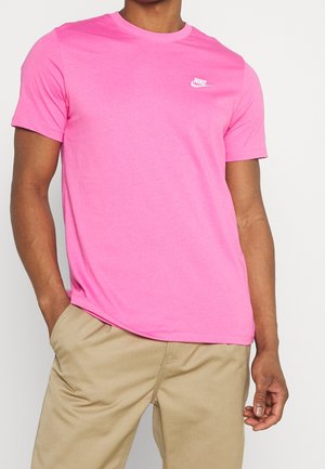 Růžové tričko Nike s kulatým výstřihem a krátkými rukávy, vyrobené z bavlny, s malým bílým logem na levé straně hrudi.