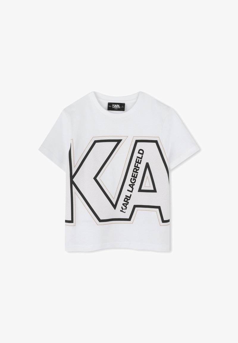 T-shirt cropped en coton blanc avec un grand logo "KA" noir et doré, comprenant des lignes diagonales, des manches courtes et un col rond.