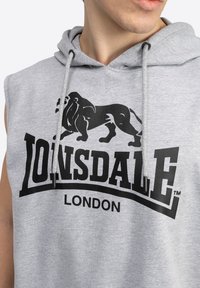 Gray sleeveless hoodie with drawstrings, featuring a prominent black lion graphic and "LOINSDDALE LONDON" text in bold. Soft texture.