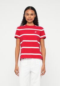 Red striped t-shirt made of cotton, featuring white horizontal stripes, short sleeves, and a rounded neckline, with a small logo on the chest.