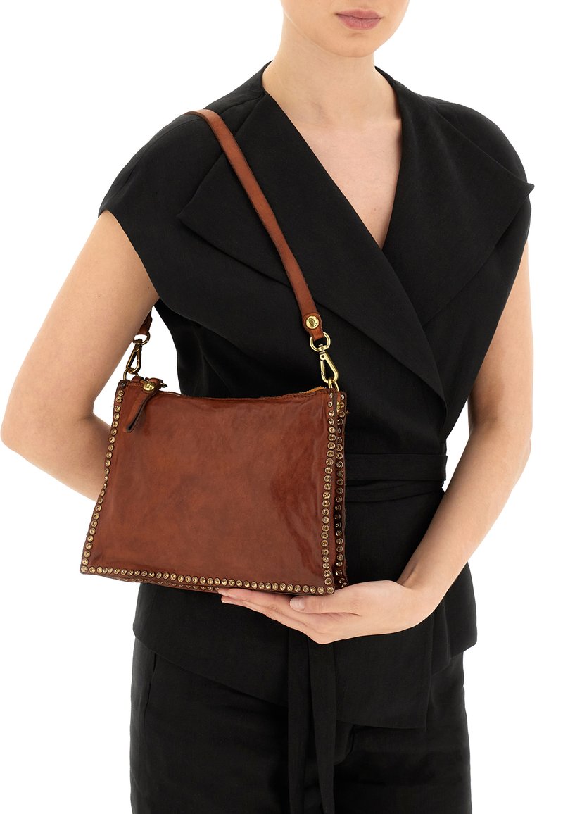 Borsa a mano in pelle marrone con dettagli borchiati dorati, forma rettangolare, tracolla regolabile e chiusura con cerniera. Texture liscia.