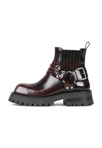 Bottines en cuir verni bordeaux avec un panneau nervuré, accent en boucle et semelle en caoutchouc noire rugueuse. Bout rond et talon de hauteur intermédiaire.