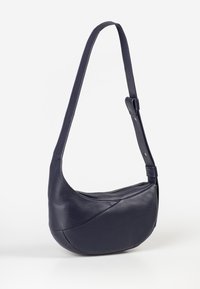 Borsa a spalla in pelle blu navy con design curvo, chiusura con zip e tracolla regolabile. La texture morbida e i dettagli senza soluzione di continuità aggiungono un tocco di eleganza.