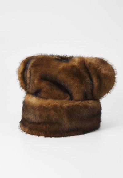 Brun kunstpelslue med en avrundet topp og bred bånd, med myk, glatt tekstur og subtile mørke striper. Kompakt design, varmt utseende.