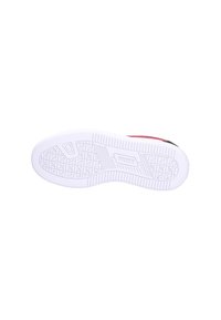 Suela de goma blanca de una zapatilla Puma roja y negra, mostrando un patrón de huellas texturizado y el logo de Puma estampado en el centro.