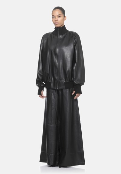 Giacca bomber in pelle nera con colletto alto, polsini a coste e pantaloni in pelle a gamba larga abbinati, caratterizzati da una texture liscia e un design minimalista.