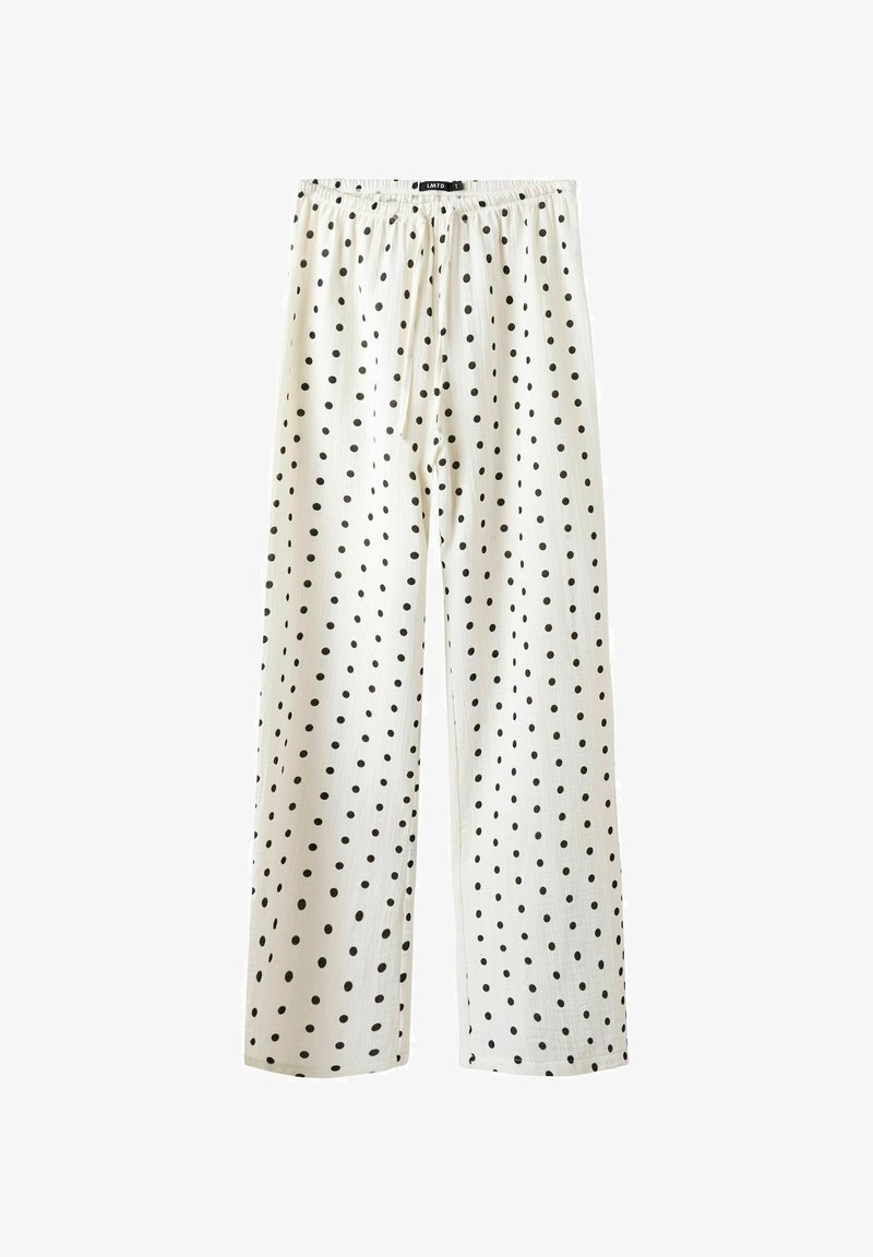 Vita byxor med svarta prickar, med elastisk midja och vida ben. Tillverkade av ett lätt tyger med mjuk textur.