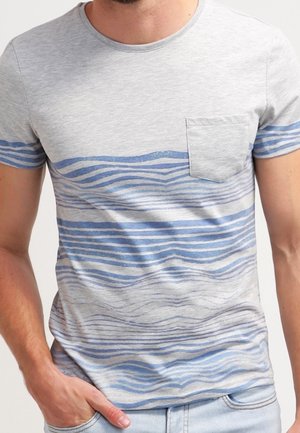 T-shirt en coton gris avec un motif de vagues bleues sur la poitrine et une petite poche sur le côté gauche. Manches courtes et design col rond.
