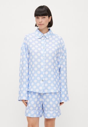 Light blue polka dot pajama set with a collared button-up shirt and matching shorts. The fabric has a textured finish with white circular patterns.