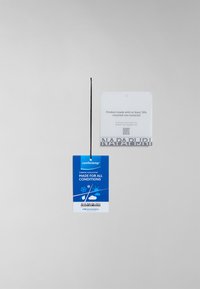 Étiquette de produit bleue et blanche avec une ficelle noire. Affiche "comfortemp," des détails sur le produit, et un code QR. Le texte mentionne des matériaux recyclés.