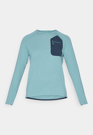 Long-sleeve shirt in light blue textured fabric. Features a navy pocket with branding. Round neckline and curved hem design.