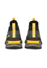 Ein Paar schwarze und gelbe Sportschuhe, von hinten betrachtet, mit gelben Fersen-Schlaufen und Blockabsätzen auf weißem Hintergrund.