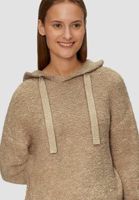 Hoodie in lichtbeige, gemaakt van textuurstof. Voorzien van platte beige trekkoorden en een relaxte pasvorm.