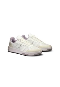 White athletic shoes with a smooth leather upper, mesh accents, perforation details, and a contrasting gray outsole.