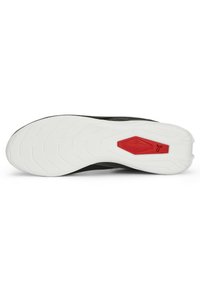 Černá atletická podrážka s bílým gumovým základem, s texturovanými vzory a červeným akcentem v oblasti mezipodešve.