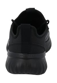 Svart sportskor med ett strukturerat mesh-övre, vadderad krage, ögla för att dra i skorna och en tjock, stötdämpande sula för stöd.