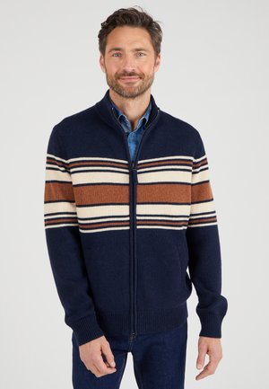 Suéter azul marino con cierre de cremallera, con rayas horizontales en beige y marrón. Fabricado en tejido texturizado, incluye bolsillos laterales y puños acanalados.