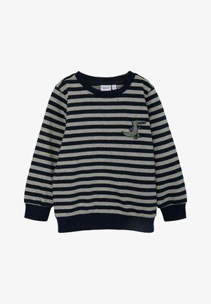 Sweatshirt rayé en navy et gris. Matière douce avec des manches longues, des poignets côtelés et un petit motif vert brodé sur la poitrine.