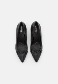 Scarpe con tacco alto in pelle nera, con punta appuntita e dettaglio intrecciato nella parte anteriore. Presentano una soletta perforata per favorire la traspirazione.