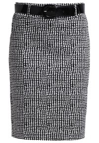 Svart och vit mönstrad kjol i penningform, med en texturerad design av små prickar och ett blankt svart bälte med en rund spänne.