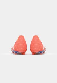 Botas de fútbol de un brillante color naranja con una parte superior texturizada, patrones angulares y acentos morados en la suela. Diseñadas para el rendimiento y la tracción.